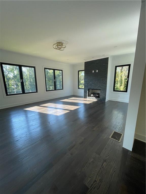 unfurnished living room with dark hardwood / wood-style flooring and a large fireplace