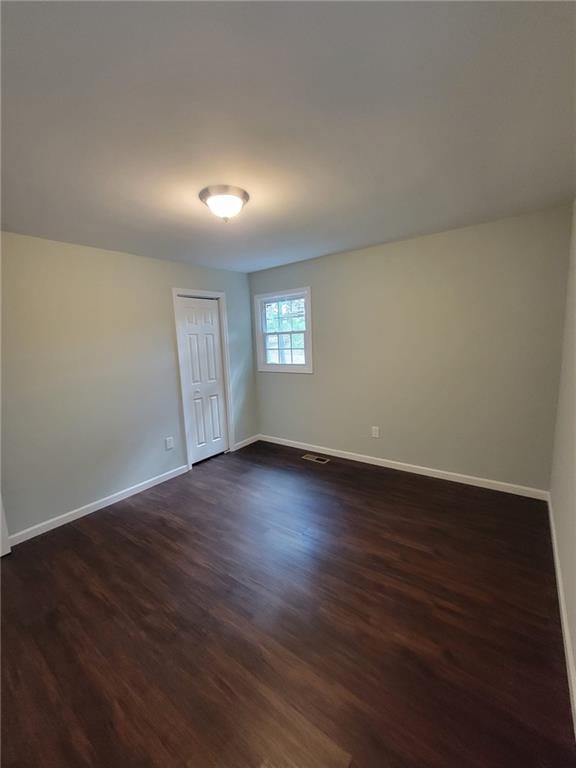 unfurnished room with dark hardwood / wood-style flooring