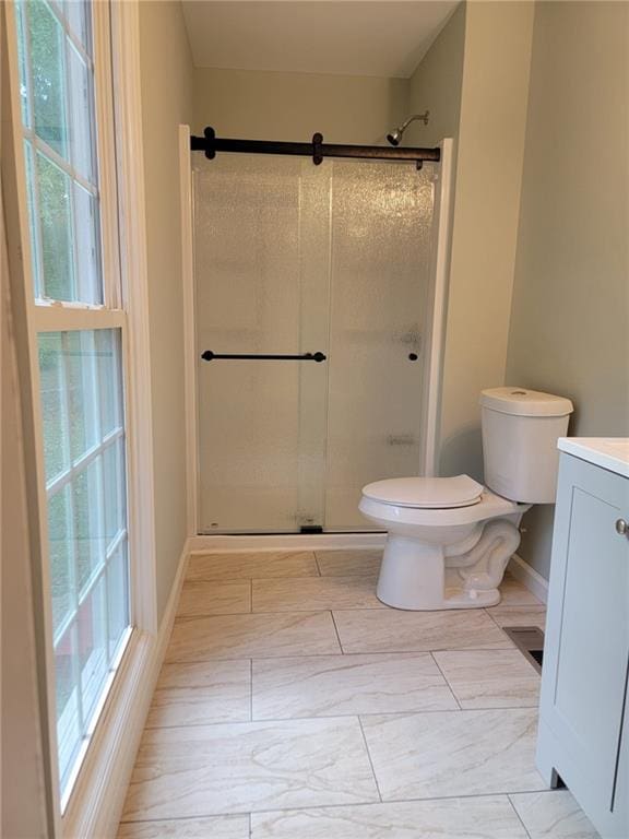 bathroom featuring toilet, walk in shower, and vanity