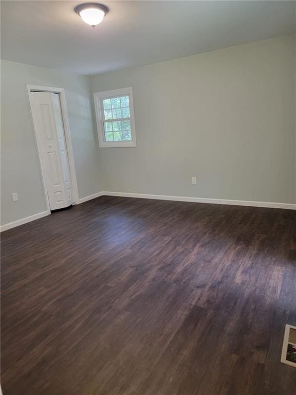 spare room with dark hardwood / wood-style floors