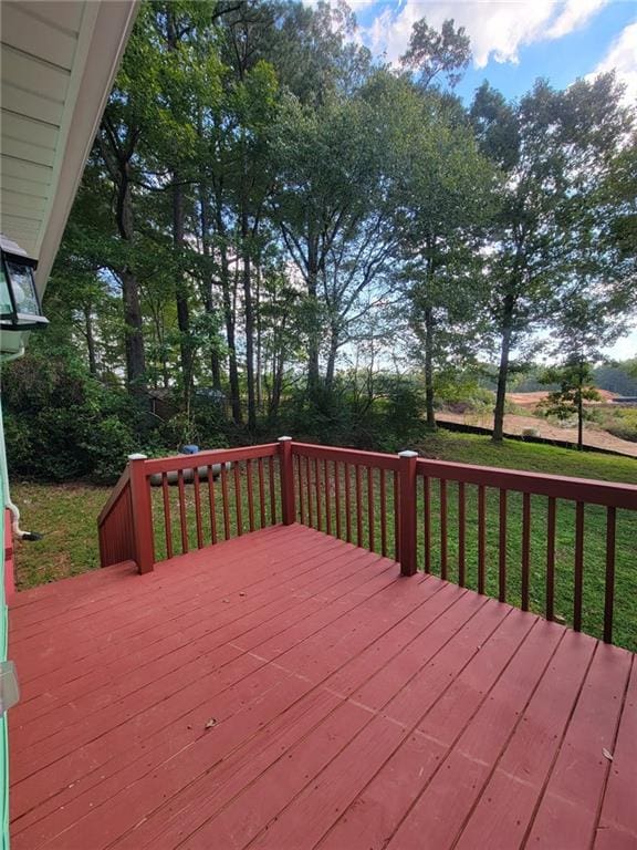 wooden deck featuring a lawn