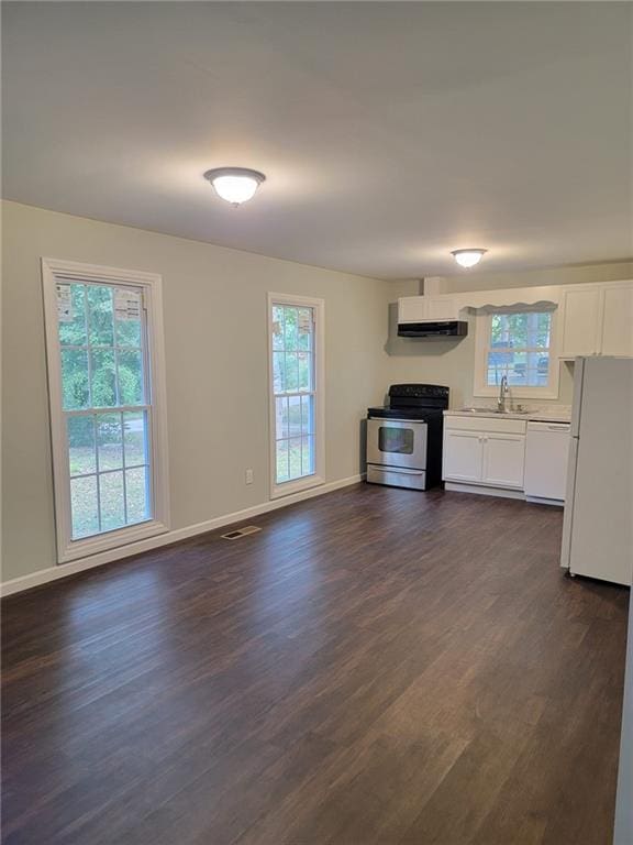 kitchen with dark hardwood / wood-style flooring, white cabinets, white appliances, and plenty of natural light