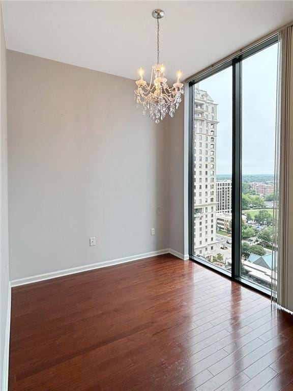 3040 Peachtree Rd NW Unit 1501, Atlanta, GA 30305 - spare room with a chandelier, a wall of windows, dark wood-type flooring, and baseboards