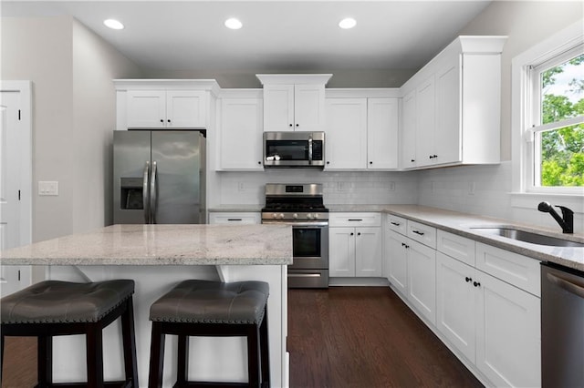 35 Bridgestone Way SE, Cartersville, GA 30120 - kitchen with stainless steel appliances, a breakfast bar, white cabinetry, recessed lighting, and dark wood-style flooring