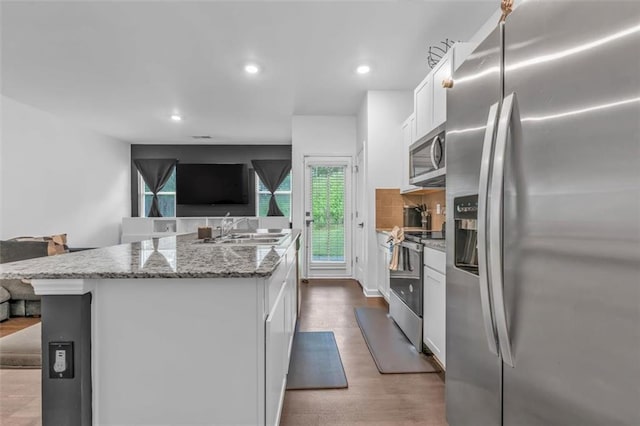 5668 Union Pointe Dr, Union City, GA 30291 - kitchen with appliances with stainless steel finishes, open floor plan, a sink, white cabinets, and recessed lighting