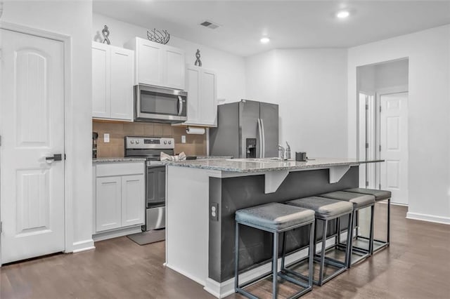 5668 Union Pointe Dr, Union City, GA 30291 - kitchen with stainless steel appliances, dark wood-style flooring, a kitchen island with sink, a kitchen bar, and recessed lighting