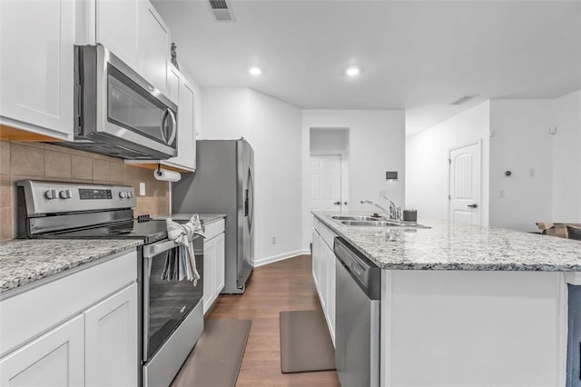 5668 Union Pointe Dr, Union City, GA 30291 - kitchen featuring appliances with stainless steel finishes, a sink, an island with sink, dark wood-type flooring, and backsplash
