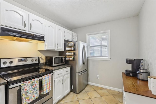 kitchen with under cabinet range hood, stainless steel appliances, dark countertops, and white cabinets