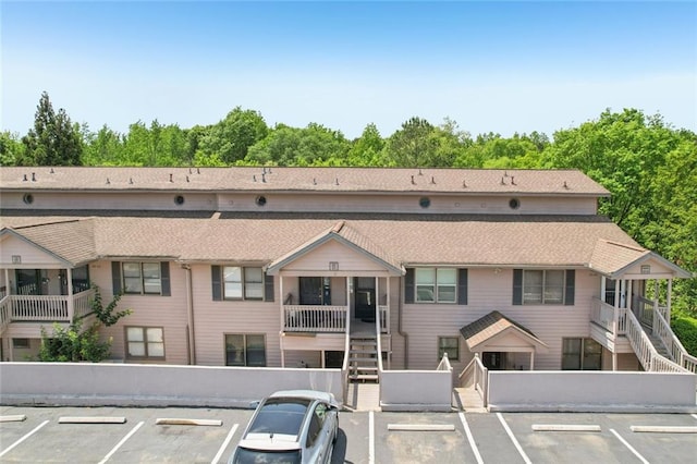 view of property featuring stairs and uncovered parking
