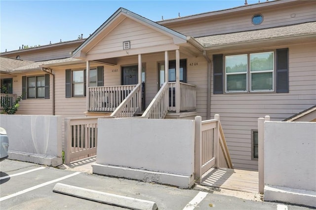 multi unit property with a gate, a fenced front yard, a porch, and uncovered parking