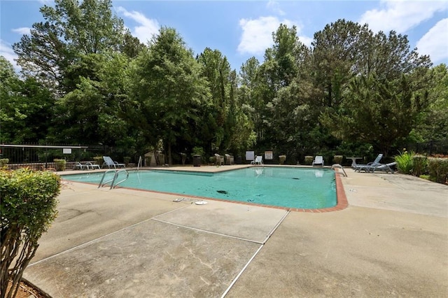 pool with fence and a patio area