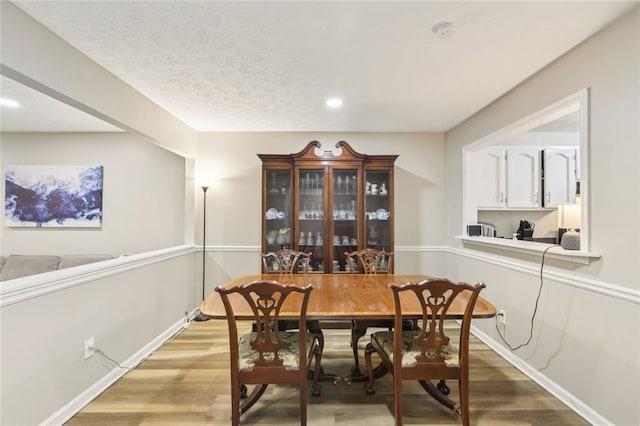 dining space featuring light wood-style floors, baseboards, and recessed lighting