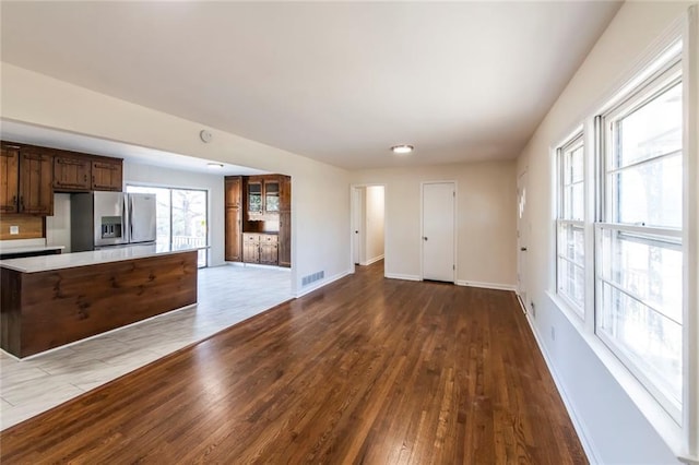 kitchen featuring stainless steel refrigerator with ice dispenser, a wealth of natural light, and hardwood / wood-style flooring