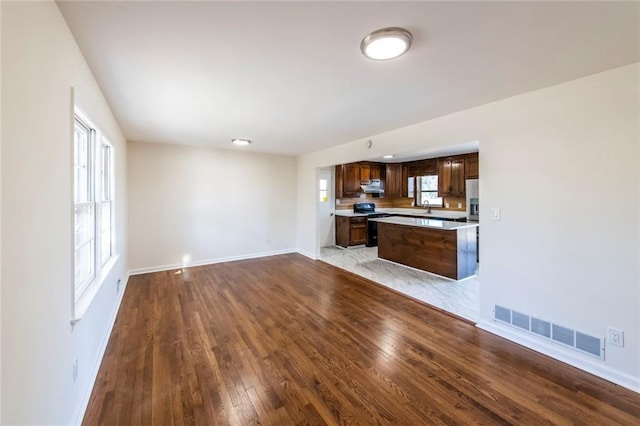 unfurnished living room featuring sink and light wood-type flooring