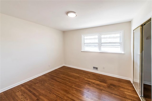 unfurnished bedroom with a closet and dark hardwood / wood-style floors