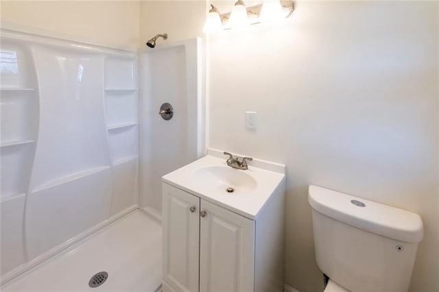 bathroom with toilet, walk in shower, and vanity