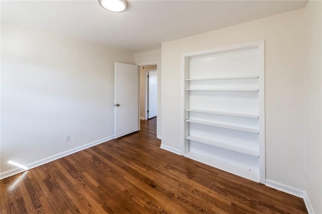 unfurnished bedroom featuring a closet and dark hardwood / wood-style floors