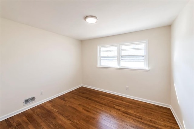 unfurnished room with dark wood-type flooring