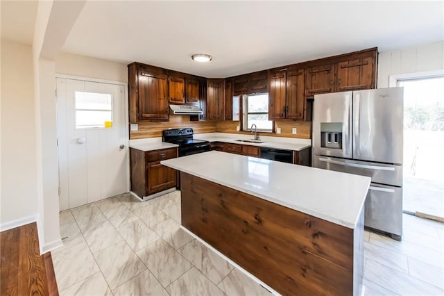 kitchen featuring black appliances, a kitchen island, dark brown cabinets, and sink