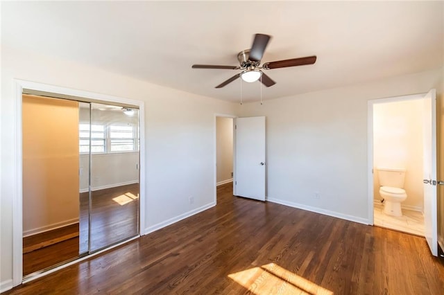 unfurnished bedroom featuring ceiling fan, connected bathroom, dark hardwood / wood-style floors, and a closet