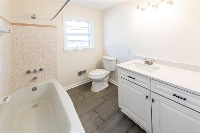 full bathroom featuring tiled shower / bath combo, toilet, and vanity