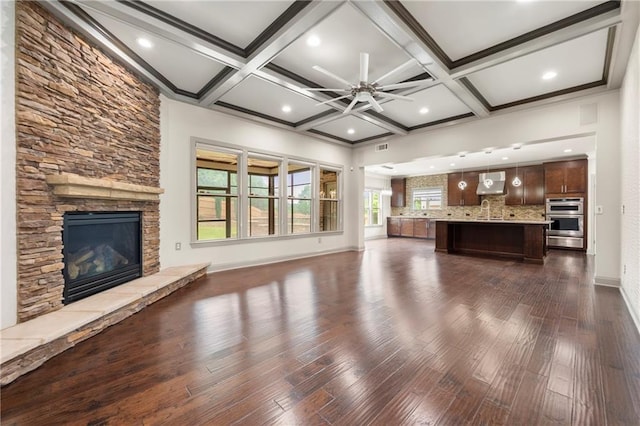 4015 Roberts Crest Ln, Suwanee, GA 30024 - unfurnished living room featuring a stone fireplace, a ceiling fan, baseboards, dark wood-style floors, and beamed ceiling