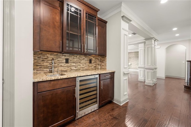 4015 Roberts Crest Ln, Suwanee, GA 30024 - indoor wet bar featuring beverage cooler, crown molding, arched walkways, ornate columns, and decorative backsplash