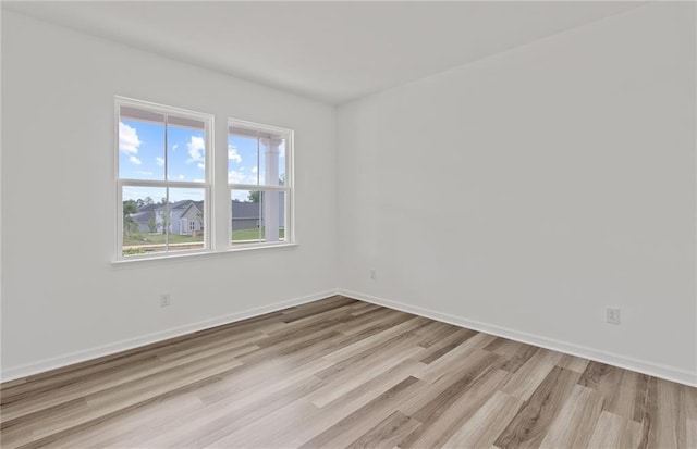 spare room with light wood finished floors and baseboards