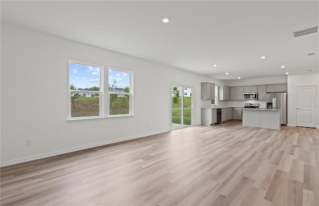 unfurnished living room with light wood finished floors, baseboards, visible vents, and recessed lighting