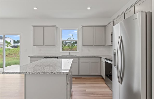 kitchen featuring recessed lighting, gray cabinetry, a sink, appliances with stainless steel finishes, and decorative backsplash