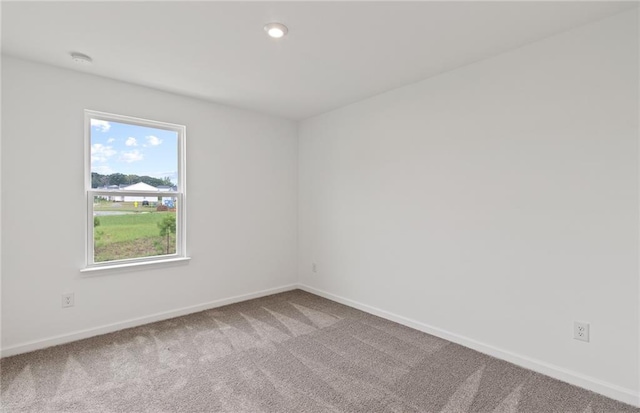 carpeted spare room featuring recessed lighting and baseboards