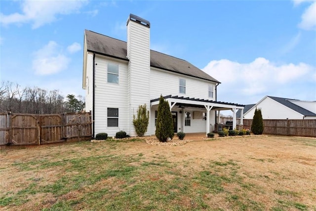 rear view of property featuring a pergola and a lawn