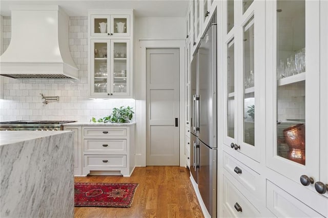 3842 Ernest W Barrett Pkwy SW, Marietta, GA 30064 - kitchen featuring wall chimney exhaust hood, white cabinets, high quality fridge, and backsplash