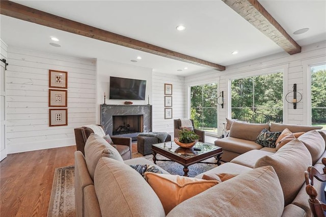 3842 Ernest W Barrett Pkwy SW, Marietta, GA 30064 - living area with wood finished floors, beam ceiling, a high end fireplace, wood walls, and recessed lighting