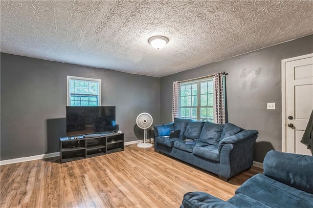 504 J C Daniel Rd, Carrollton, GA 30117 - living area featuring healthy amount of natural light, wood finished floors, baseboards, and a textured ceiling