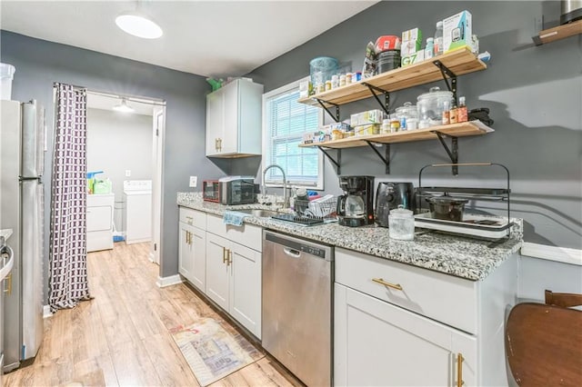 504 J C Daniel Rd, Carrollton, GA 30117 - kitchen featuring stainless steel appliances, a sink, light wood-style flooring, and washing machine and clothes dryer