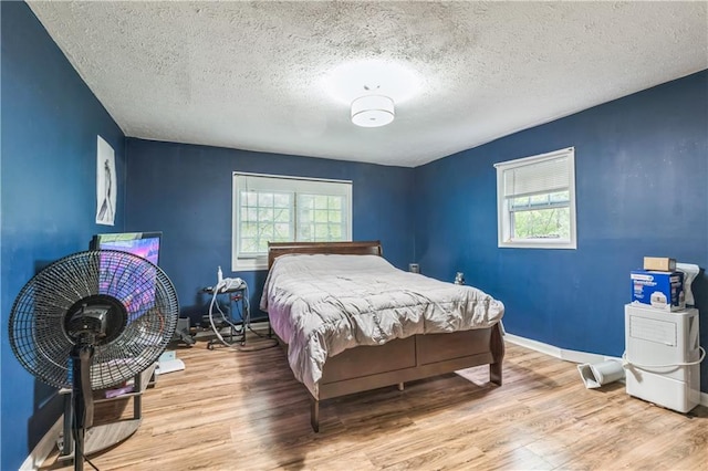 504 J C Daniel Rd, Carrollton, GA 30117 - bedroom with multiple windows, wood finished floors, a textured ceiling, and baseboards