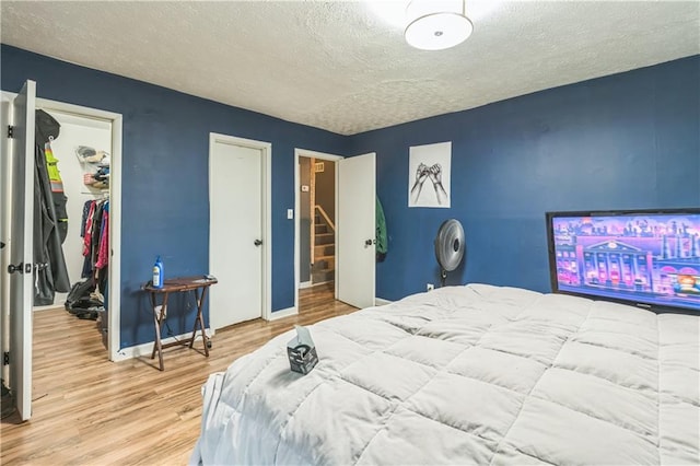 504 J C Daniel Rd, Carrollton, GA 30117 - bedroom featuring wood finished floors, a textured ceiling, a walk in closet, baseboards, and a closet