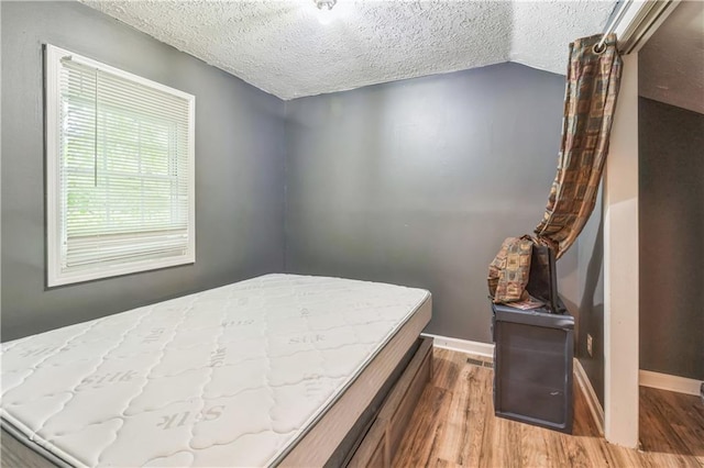 504 J C Daniel Rd, Carrollton, GA 30117 - bedroom with a textured ceiling, wood finished floors, baseboards, and vaulted ceiling