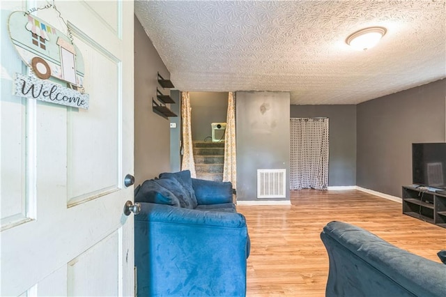 504 J C Daniel Rd, Carrollton, GA 30117 - living area featuring wood finished floors, a textured ceiling, stairway, and baseboards