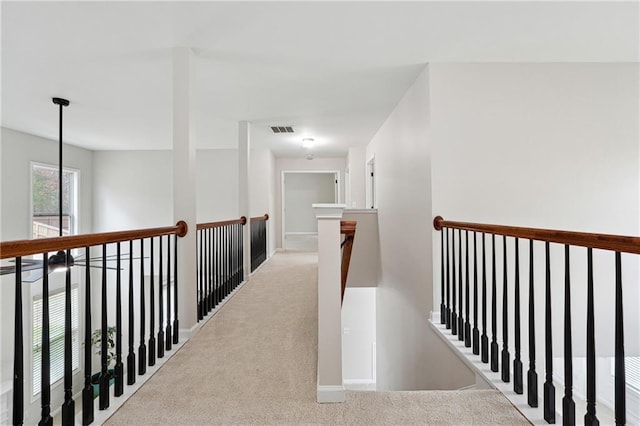 corridor featuring light colored carpet