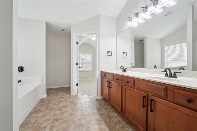 bathroom featuring vanity, lofted ceiling, tile patterned floors, and a tub to relax in