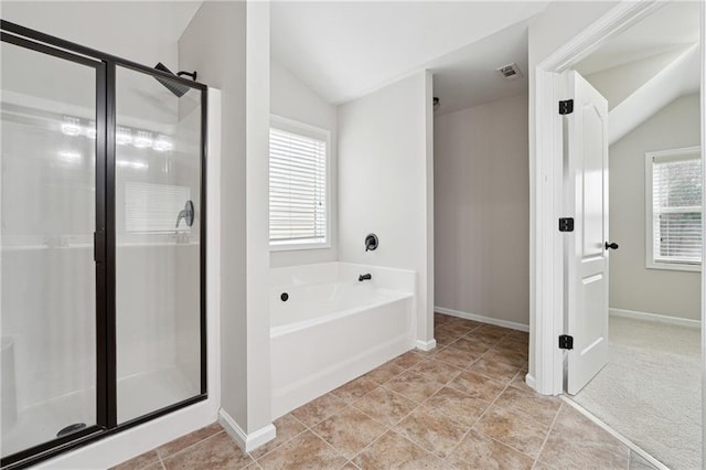 bathroom with tile patterned floors, independent shower and bath, and vaulted ceiling