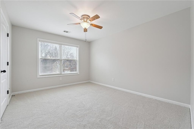 carpeted spare room featuring ceiling fan