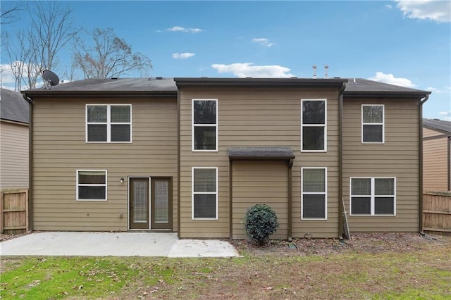 back of property with a patio area and a lawn