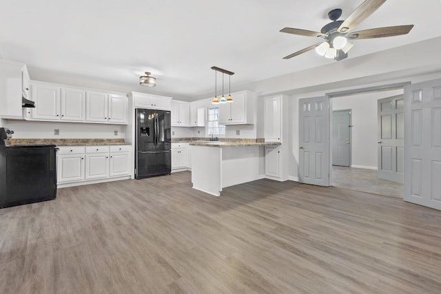 kitchen with a peninsula, black appliances, light wood-type flooring, and white cabinets