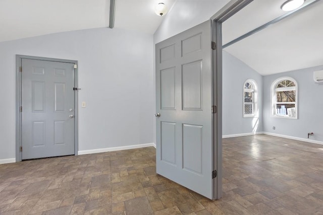 entrance foyer with vaulted ceiling with beams, stone finish flooring, and baseboards