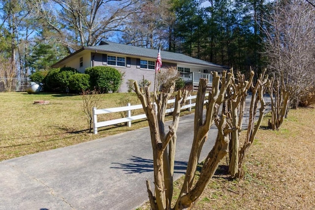 exterior space with a front yard, fence, driveway, and stucco siding