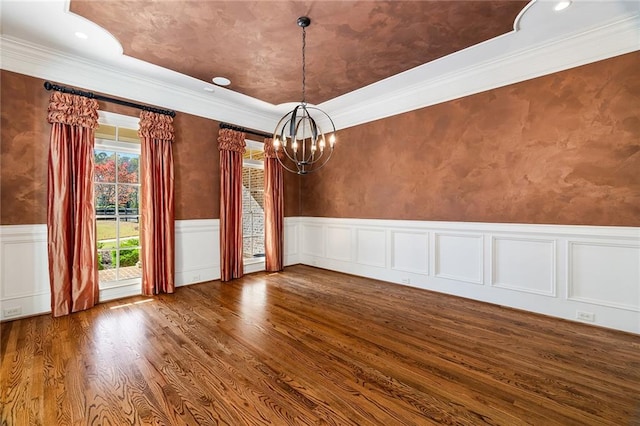 unfurnished dining area featuring crown molding, wood-type flooring, and an inviting chandelier