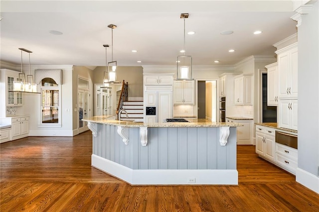 kitchen with a large island, a kitchen bar, white cabinetry, and dark wood-type flooring